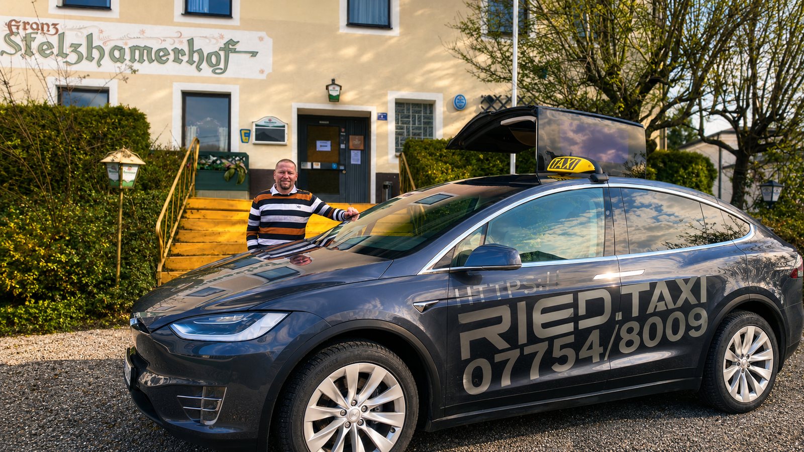 RIED.TAXI Tesla Model X mit Fahrer vor dem Franz Stelzhamerhof in Schildorn